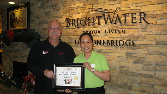 Food Safety 1st, Russell Scott presents Rose Marilou Delos Santos of Brightwater Sr Living the 8,000th Food Safety 1st certificate