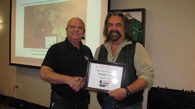Food Safety 1st, Russell Scott presents Douglas Terry from Melfort Sask. the 9,000th Food Safety 1st certificate!