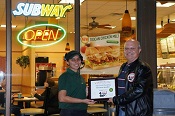Russell Scott presents Ramneet Sandhu of Subway Restaurant the 4,000th Food Safety 1st certificate.