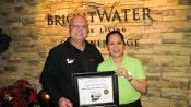Russell Scott presents Rose Marilou Delos Santos of Brightwater Sr. Living the 8,000th Food Safety 1st certificate.